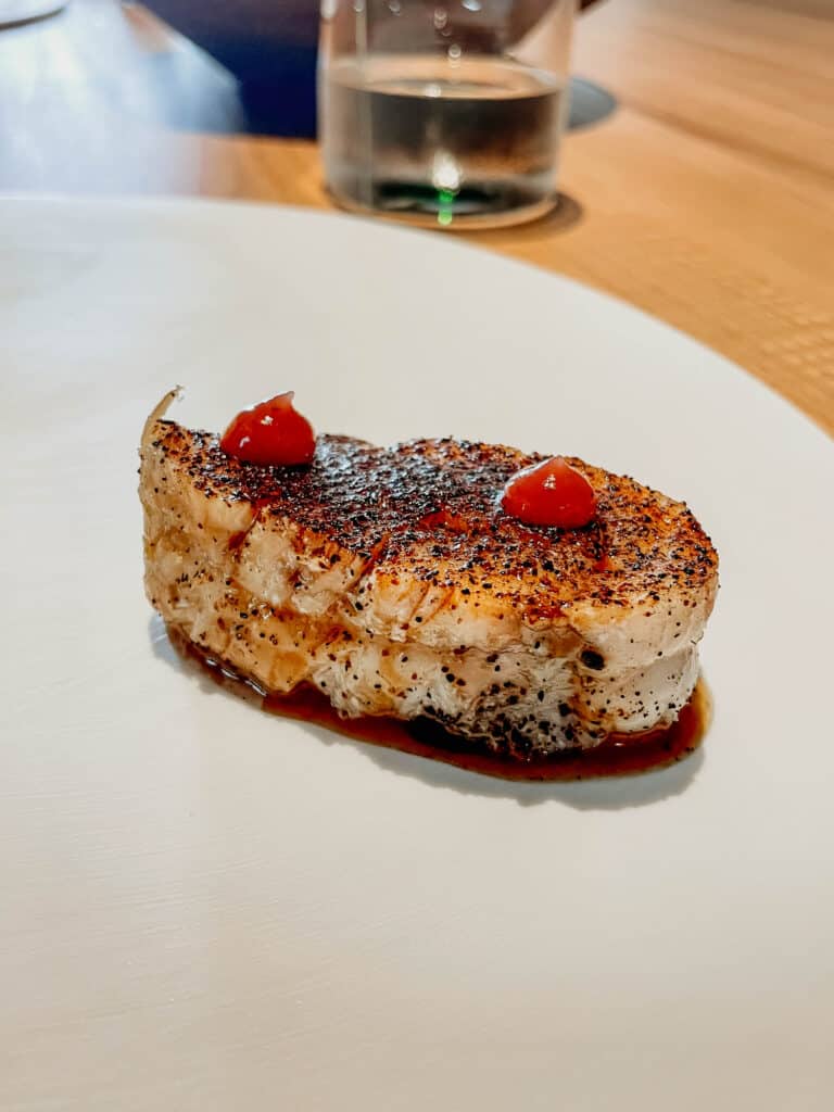 Trancio di pescatrice con aglio nero fermentato e umeboshi